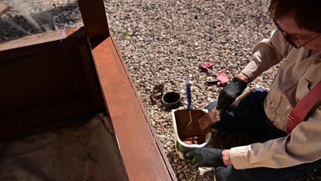 man sitting on ground and painting patio - close up