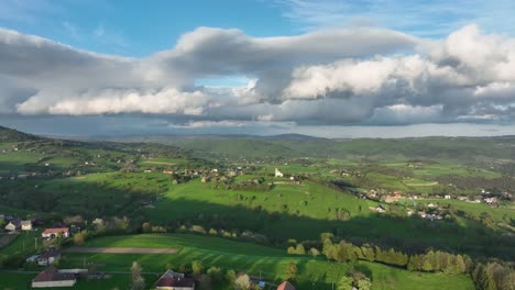 rural sanctuary: while the drone moves forward, it uncovers a modern hilltop church on a tranquil spring evening, hovering above a countryside and village, framed by dramatic clouds