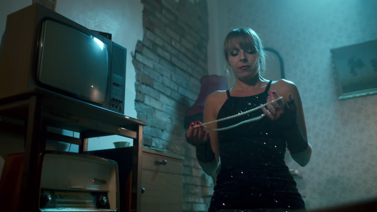 Woman in vintage dress examining pearls in a retro room