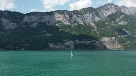 Während-Ruhige-Wellen-Die-Küste-Erreichen,-Schafft-Einsames-Yachtsegeln-Eine-Friedliche-Szene