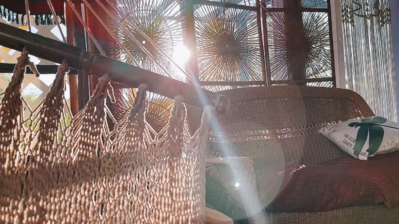 Rustic Boho Hammock and Wicker Furniture in a Sunlit Room