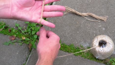 un hombre envuelve una cuerda de yute alrededor de su mano.