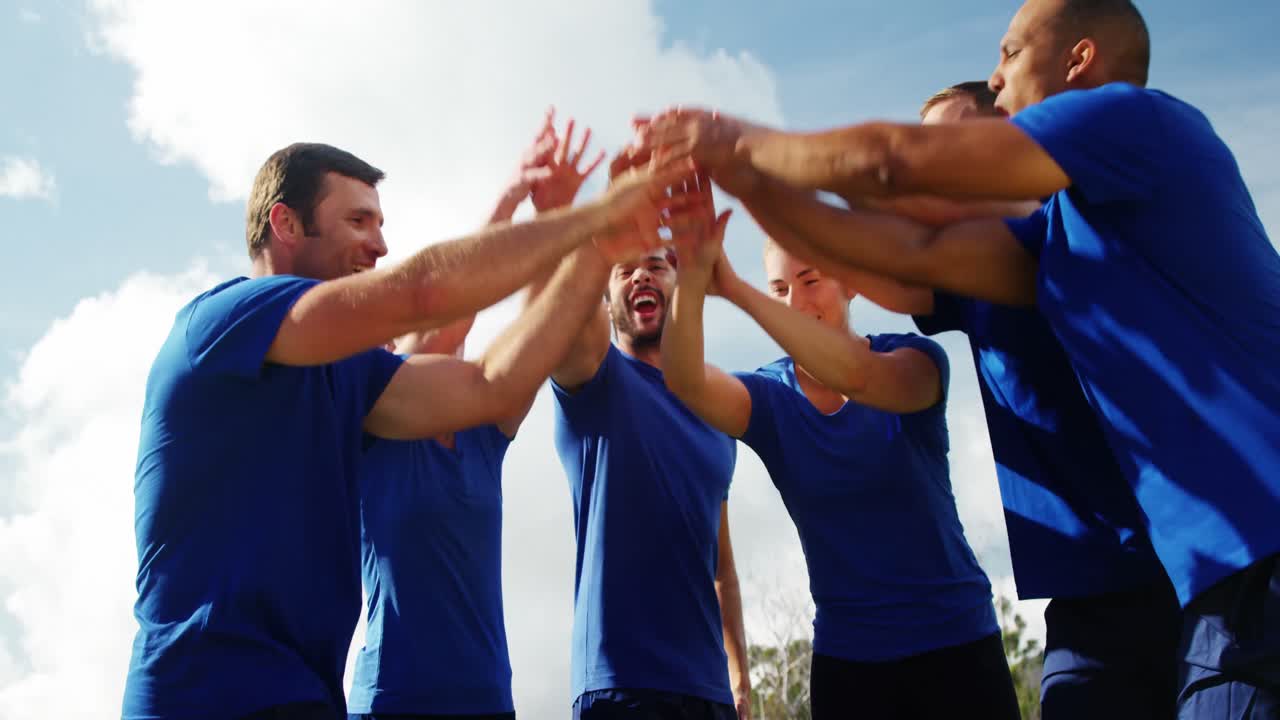 Gruppo di persone che formano una pila di mani nel boot camp 4k