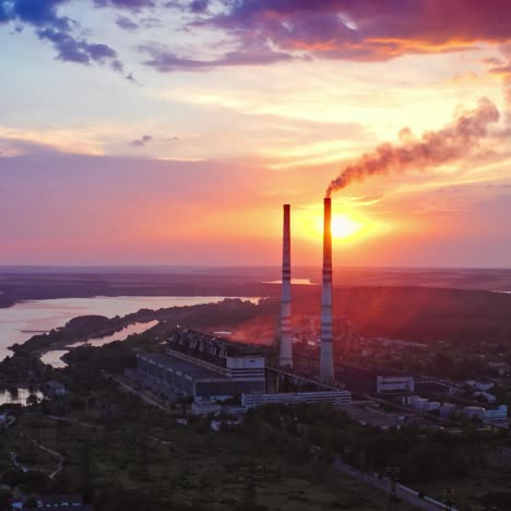 beautiful sunset with power plant on front view. red and yellow sky above river. video from drone