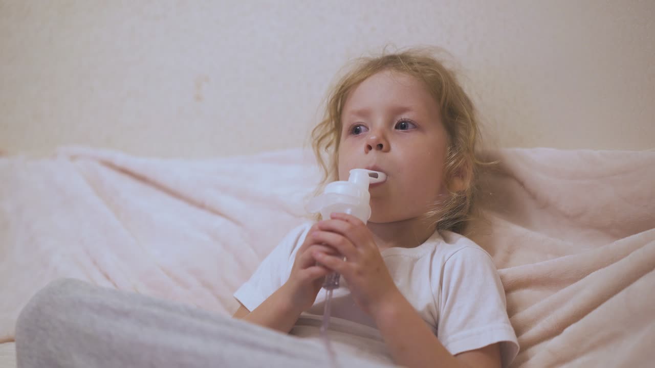 une fille bouleversée subit une procédure avec un inhalateur allongée dans son lit