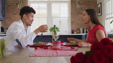 Feliz-Pareja-Birracial-Teniendo-Comida-De-Celebración-Del-Día-De-San-Valentín-En-Casa