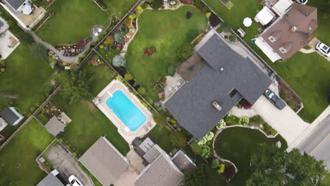 drone top down pan across suburban neighborhood backyards and homes with pools