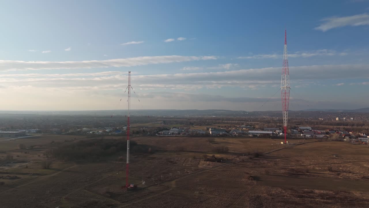 Menara Kossuth ikonik di Lakihegy, Hongaria, dengan pengaturan penyiaran bantu dan menara sampingnya, berdiri di tengah lanskap dekat Budapest dalam pemandangan drone udara dari markah tanah penyiaran nasional ini