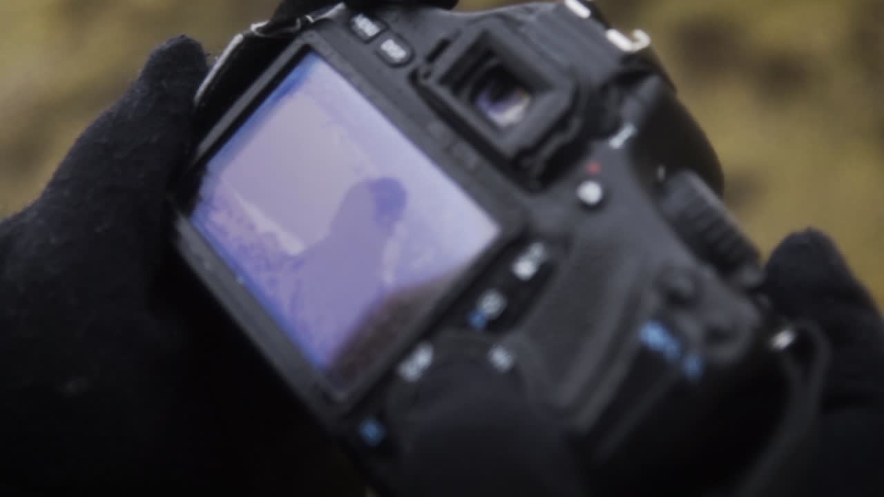 SLOW MOTION: Close Up of checking the last photos on camera on rainy day