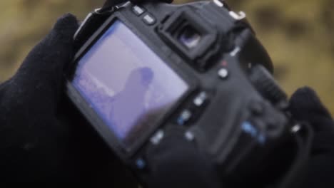 замедленная съемка: крупный план проверки последних фотографий на фотоаппарате в дождливый день