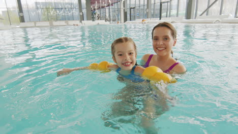 mother and daughter having fun in the swimming pool