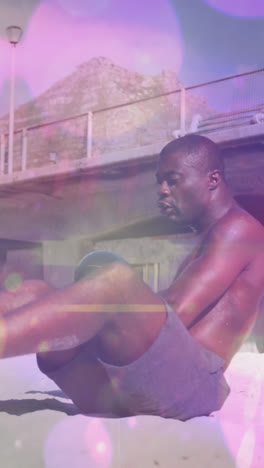 spots of light against african american fit man performing exercise with medicine ball at the beach