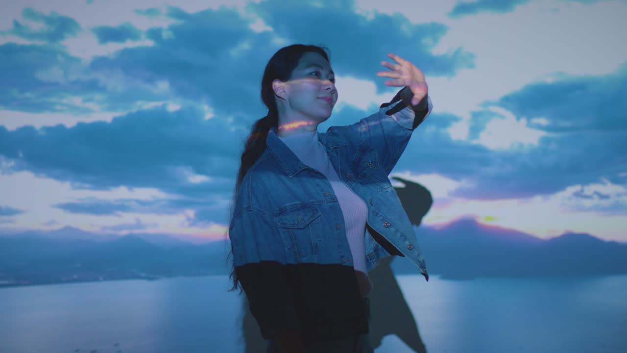 구름의 이미지가 그녀의 얼굴에 투사되는 몰입 예술 전시회를 방문하고 상호 작용하는 여성