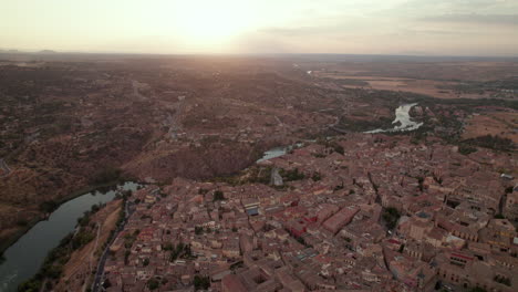 Cityscape-drone-flyover-view-of-ancient-walled-city-on-hill,-Toledo,-Spain