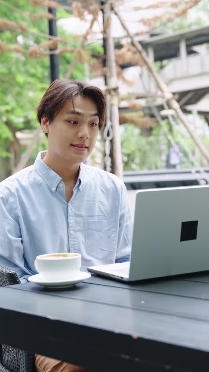 Man working on laptop at outdoor cafe