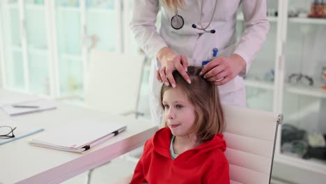 doctor examining a young girl's head during a medical check-up