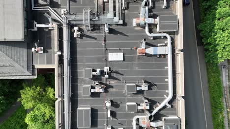 network of rooftop piping for ventilation and hvac systems on flat roof by road