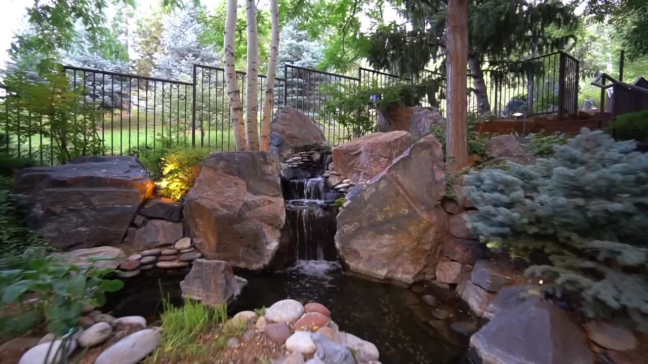 Slow motion of outdoor water feature in nicely landscaped yard.