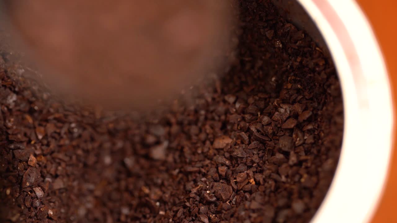 Scooping coffee grounds from container