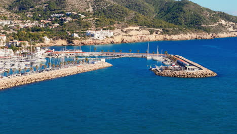 Drone-captures-sailors'-town-in-sunny-weather-with-a-beautiful-blue-sea-coast-backdrop