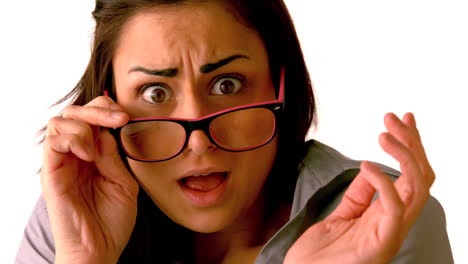 una morena conmocionada inclinando sus gafas