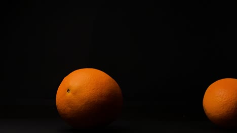 Rollende-Orangenfrucht,-Schwarzer-Hintergrund