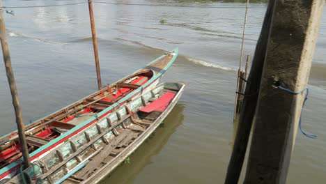 longtail boats in swell of passing boat