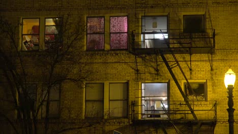 generic establishing shot of an urban tenement or apartment complex at night