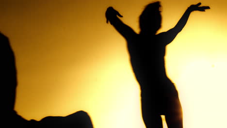 silhouette of a dancing figure in golden light