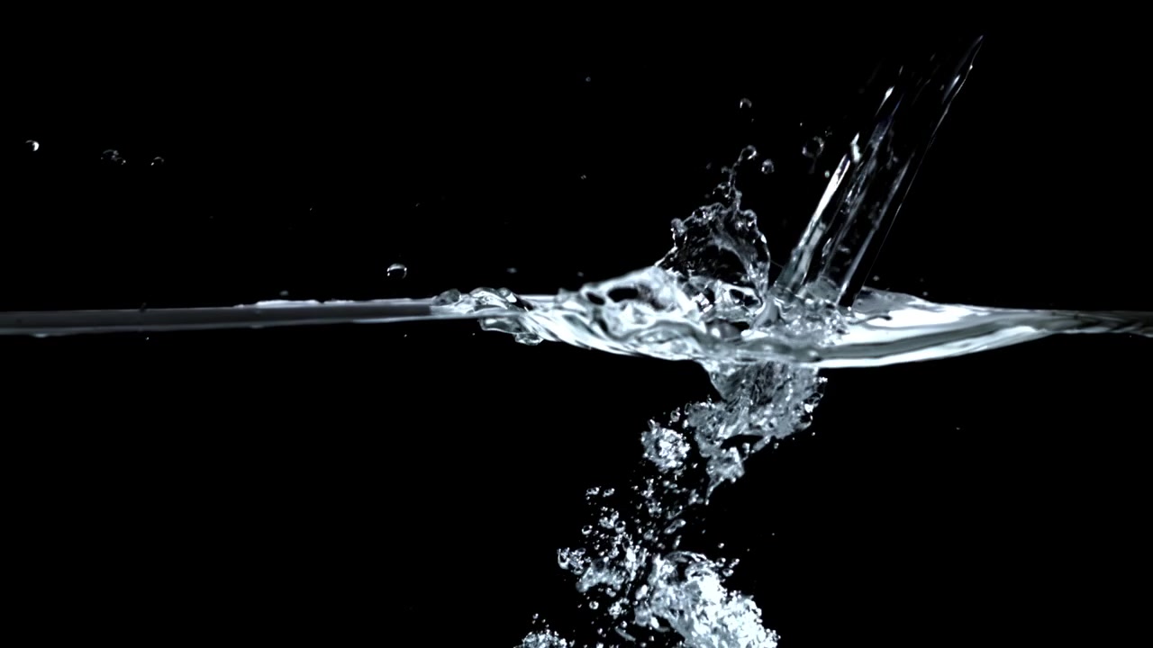 Acqua che si versa al rallentatore e crea bolle su sfondo nero
