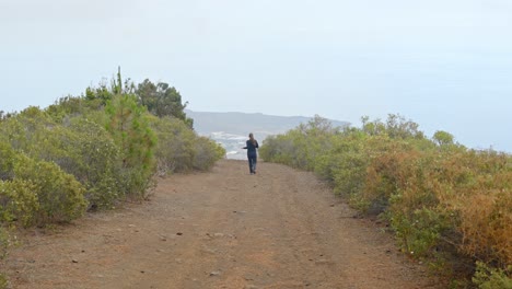 Fit-young-woman-jogging-in-Tenerife-wild-landscape,-back-view