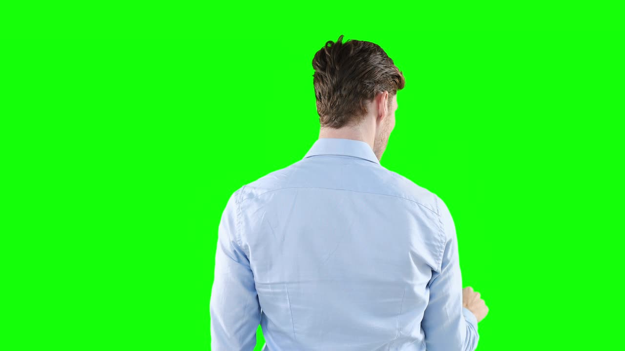 백인 남자가 녹색 배경에서 카메라로 돌아갑니다.