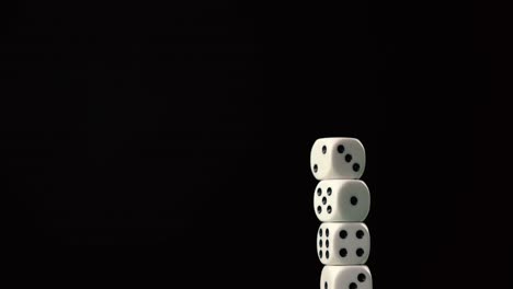 stacking dice creating a tower making it fall over