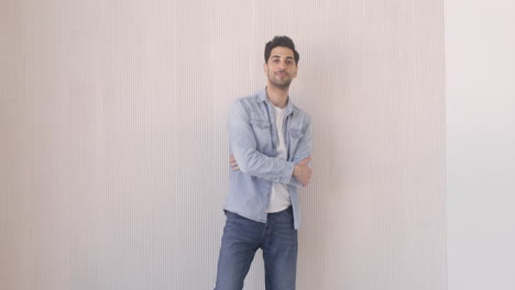 bearded man standing against the wall in a room