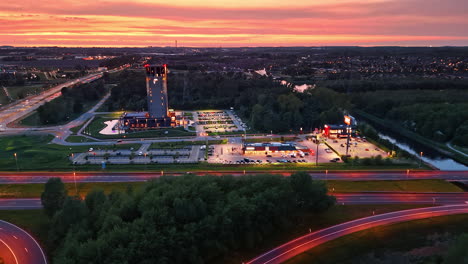 sunset over city and river. a vibrant sunset paints the sky, reflecting over a city with buildings, a river, and busy roads filled with cars