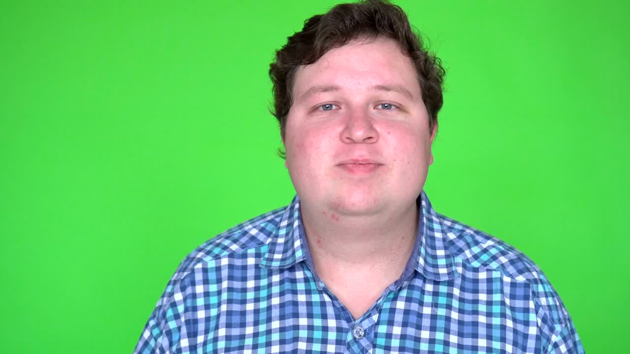 Uomo affascinante che saluta su green screen chroma key