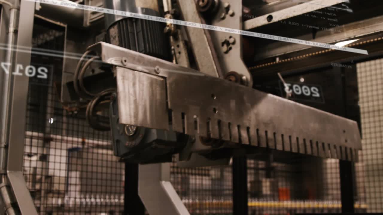 Camera panning upward from conveyor gripper unit showing parts while HUD lines tracking line flow