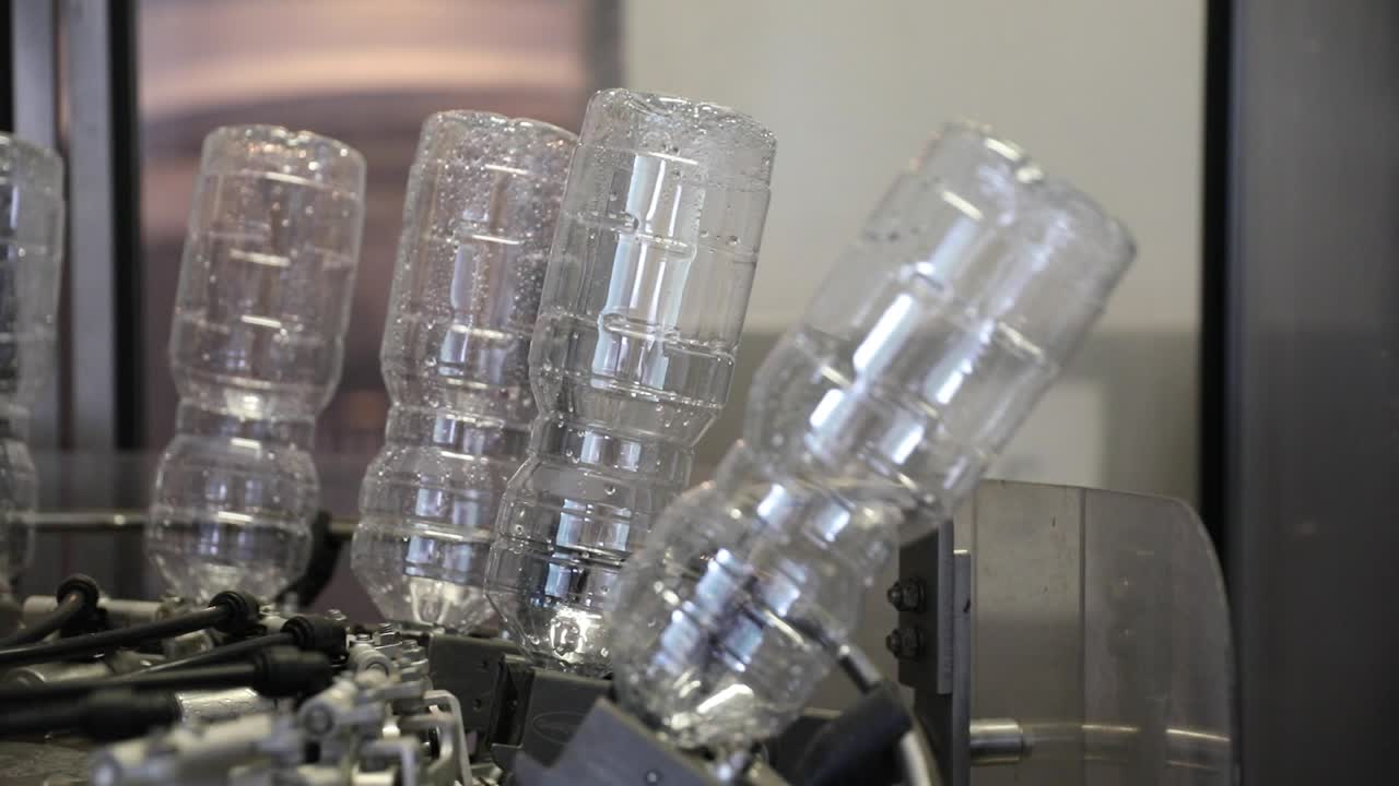Empty Plastic Bottles Upside Down After Being Cleaned and Washed Rotating on a Machine at a Vinegar Factory