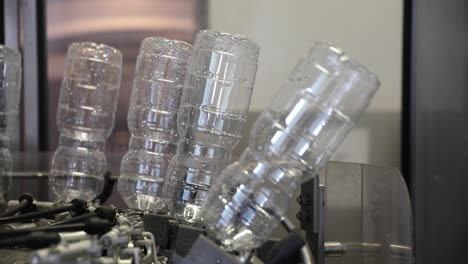 empty plastic bottles upside down after being cleaned and washed rotating on a machine at a vinegar factory