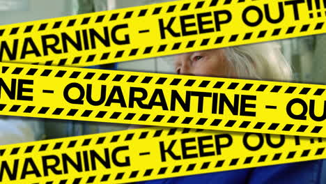 words keep out, quarantine written on yellow tape over a senior female patient. covid-19 spreading