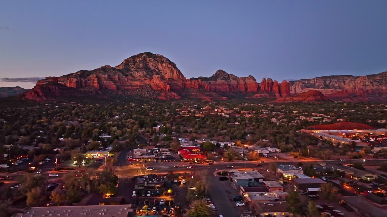 Wide cinematic twilight drone shot of Sedona Arizona with the Airport Mesa mountain in the distance