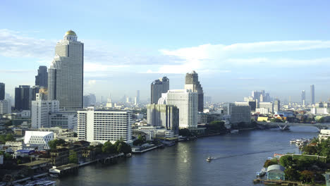 Time-lapse-Del-Río-Choa-Phraya-Mientras-Fluye-A-Través-De-Los-Modernos-Rascacielos-De-Bangkok,-Tailandia