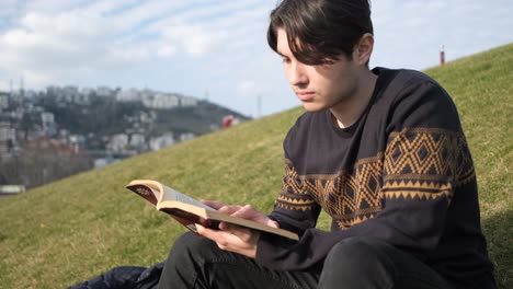 man reading novel on park