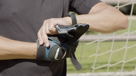 close up of an unrecognizable senior goalkeeper wearing gloves before match