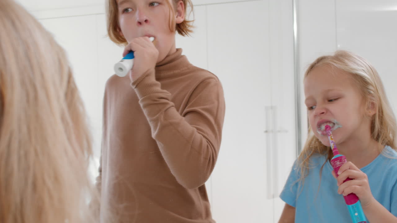 Siblings brushing teeth together