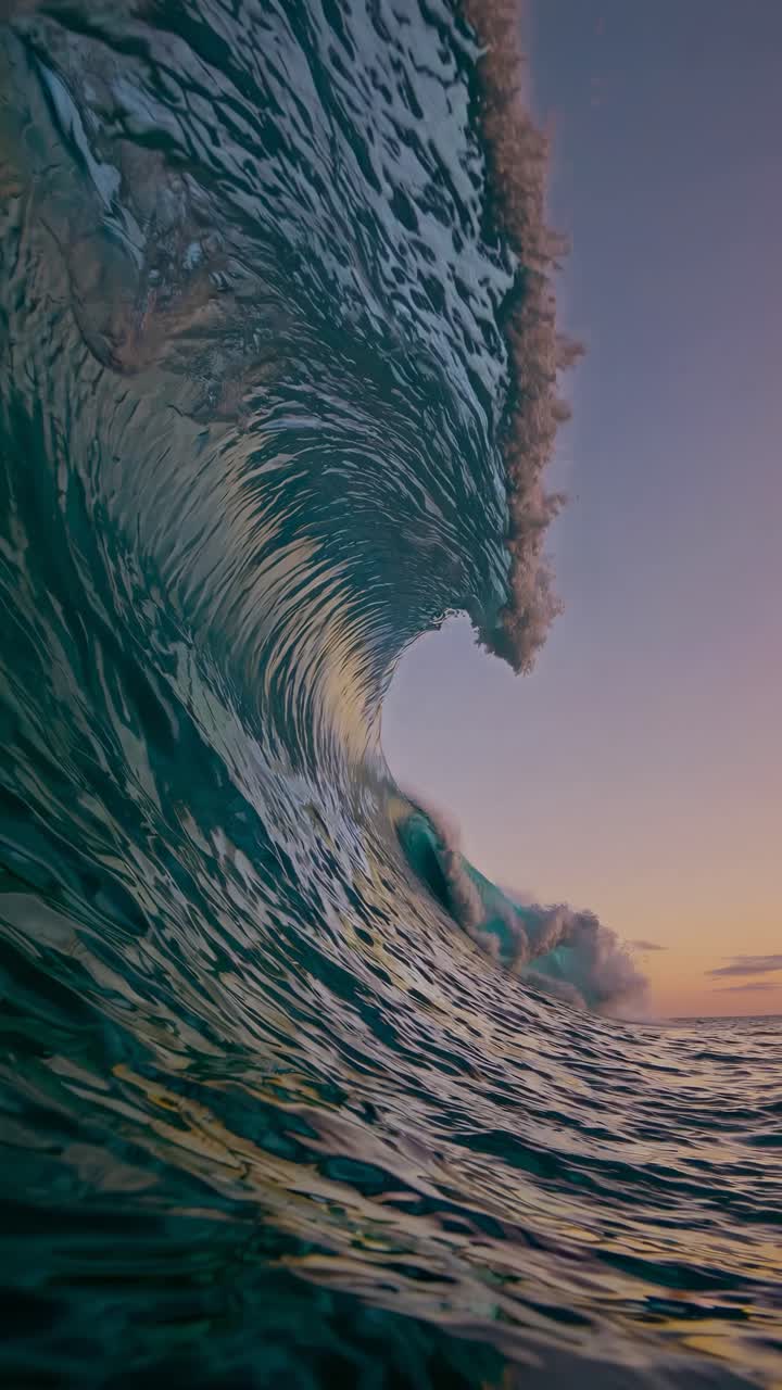 Dramatic low-angle shot of a curling ocean wave at sunset, capturing the dynamic beauty of nature