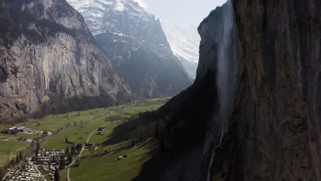 aerial flying sidewards showing lauterbrunnen and the waterfall on a sunny day, switzerland