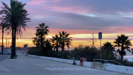 beautiful sunrise over the saint julian fort with traffic on a main road in carcavelos