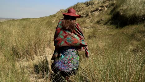 a girl walks in a grass field during a beautiful summer afternoon