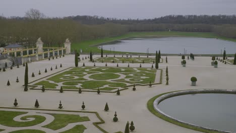 symmetrical french garden with shaped hedges and water view, versailles, paris, france